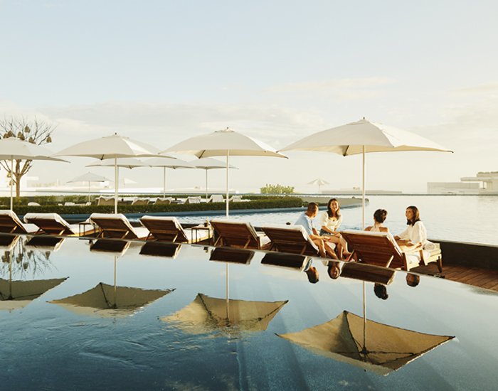 Turistas junto à piscina de um hotel durante uma estadia de lazer 